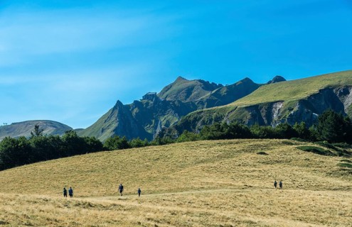 Auvergne Volcanoes Regional Park. Groups of hikers traverse a rugged path in the beautiful Sancy