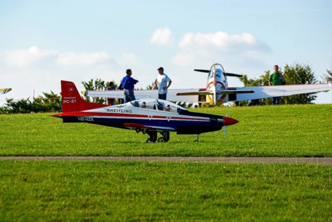 An RC model of a Pilatus PC-21 with advertising for the Swiss watch brand Breitling during a flight