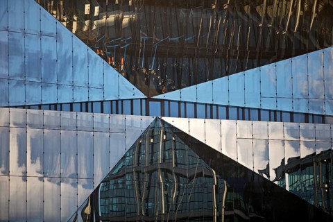 Cube Berlin, cube-shaped office building with folded glass façade reflecting the surroundings,