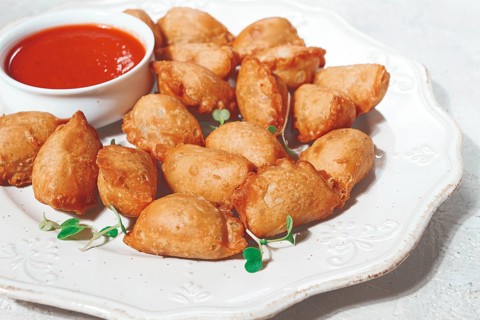 Fried mini chebureks, with sauce, on a decorative plate, hard light, no people