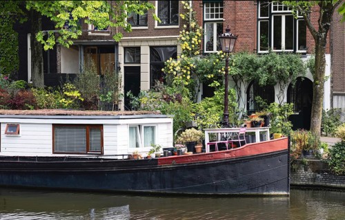 Holland, Amsterdam canals with boats, scenic bridges and historic city center, UNESCO World
