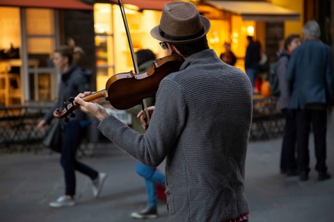 Italy, street musician entertaining tourists near landmark Florence attraction of Il Duomo