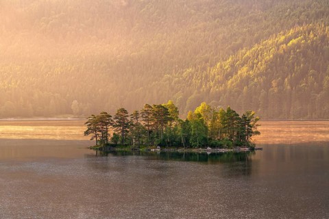 Morning atmosphere at the Eibsee lake, small island in the first light, Grainau near