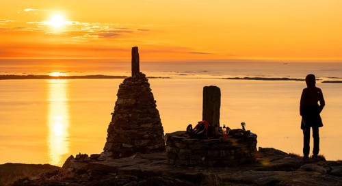 Silhouette of a woman watching the sunset next to cairns, Rørsethornet stone staircase, with 3292