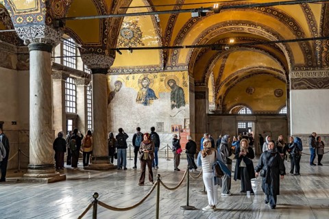 Visitors at the Deësis mosaic in the interior of today's Hagia Sophia mosque or Church of St