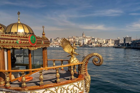 Golden oriental restaurant ship on the banks of Eminönü, Beyoglu and the Galata Tower, Istanbul,