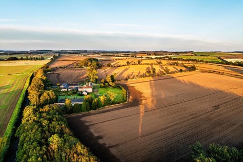 Sunset of Farms and Fields over Norham Castle from a drone, Norham, River Tweed, Northumberland,