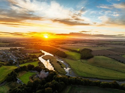Sunset over Norham Castle and River Tweed from a drone, Norham, Northumberland, England, United