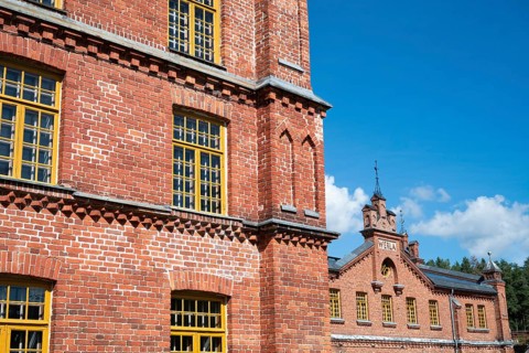 Brick façade with yellow windows, former paper factory and mill for the production of groundwood