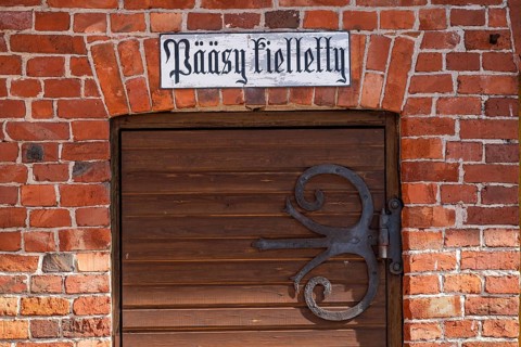 Wrought-iron fitting on wooden door and sign with Finnish inscription 'pääsy kielletty', no entry,