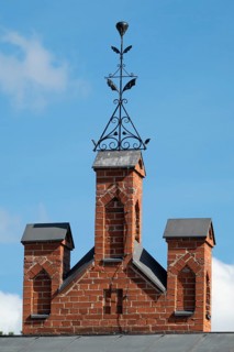 Iron ornamental element on roof peak, brick gable, former paper mill for the production of