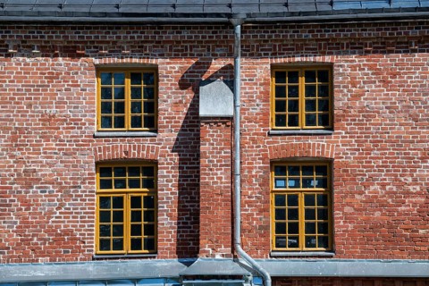 Brick façade with yellow window frames, former paper factory and mill for the production of