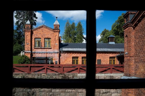 View through window frames, brick building, former paper factory and mill for the production of