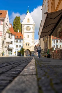 View through an alley to a historic Tor tor under a blue sky with clouds, Überlingen, Lake