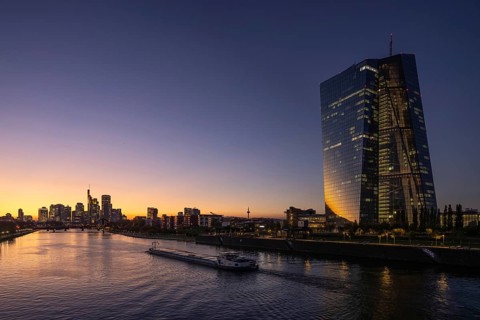 A boat cruises along the Main at sunset, in front of the European Central Bank (ECB) and the