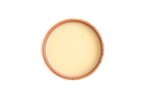 Organic non dairy banana and soy milk in clay cup isolated on white background. Vegan healthy food