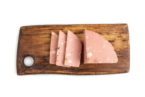 Mortadella sausage on wooden cutting board with pepper and herbs isolated on white background. Top