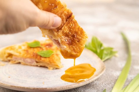 Fried homemade Khachapuri cake with hand with cheese and meat, fried in pan. Traditional Georgian