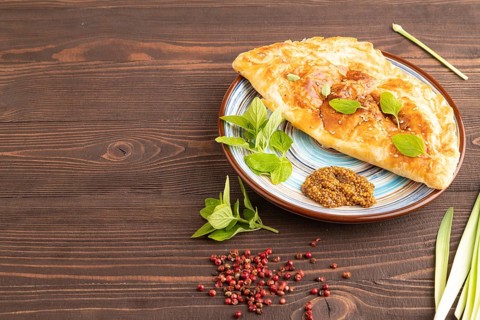 Fried homemade Khachapuri cake with cheese and meat, fried in pan. Traditional Georgian cuisine on