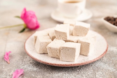 Coffee marshmallow with cup of coffee on brown concrete background. side view, close up, selective