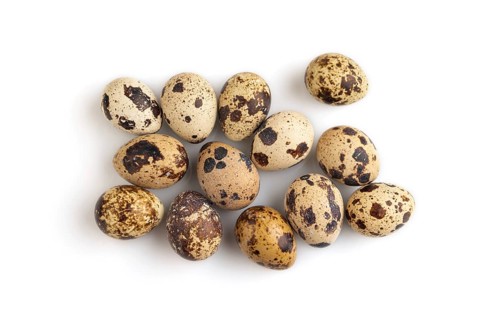 Pile of Raw Quail eggs isolated on white background. top view, flat lay, close up