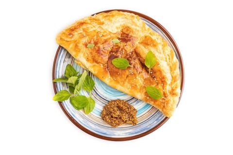 Fried homemade Khachapuri cake with cheese and meat, fried in pan. Traditional Georgian cuisine