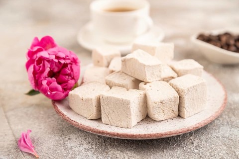 Coffee marshmallow with cup of coffee on brown concrete background. side view, close up, selective