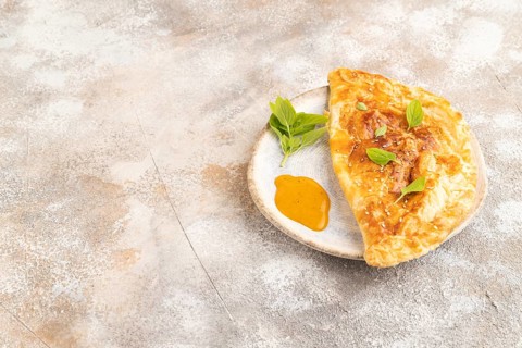 Fried homemade Khachapuri cake with cheese and meat, fried in pan. Traditional Georgian cuisine on