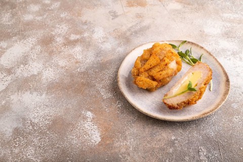 Chicken schnitzel on blue plate with microgreen on brown concrete. Diet, healthy eating. side view,