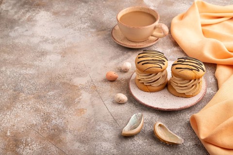 Caramel Cream Cakes on brown concrete background, cup of coffee, side view, copy space
