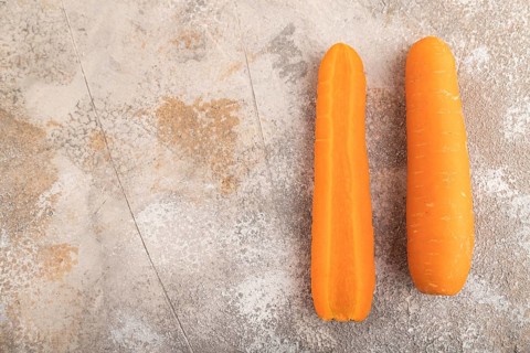 Orange Carrot on brown concrete background. Top view, copy space, flat lay. healthy food,
