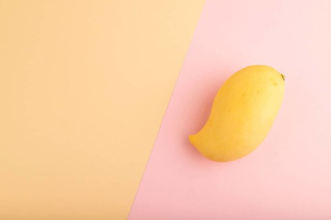 Orange mango on orange and pink paper pastel background. Top view, flat lay, copy space. healthy