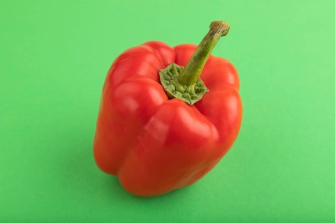 Red pepper on green pastel background. Side view, copy space. healthy food, vegetable, minimalism