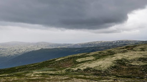 Vast mountain landscape with patches of snow and a cloudy atmosphere, pilgrimage route Olavsweg or