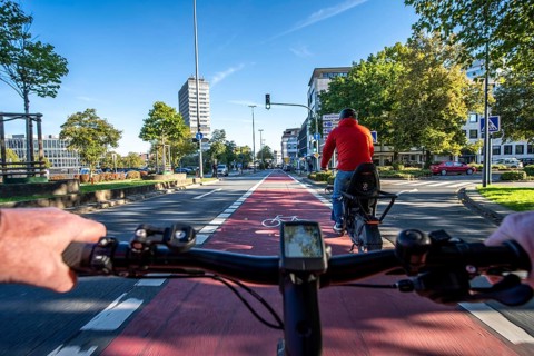 Riding a bike in a bike lane, marked in red to attract the attention of motorists, between 2 lanes,