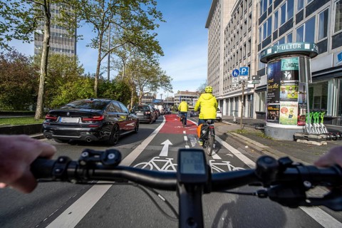 Riding a bike in a bike lane, marked in red to attract the attention of motorists, between 2 lanes,