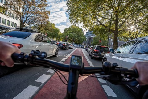 Riding a bike in a bike lane, marked in red to make drivers aware of the bike lane, between 2