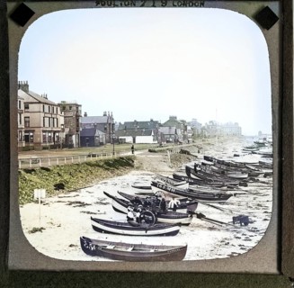 Colorised magic lantern slide by Poulton of boats on the beach in front of Esplanade buildings