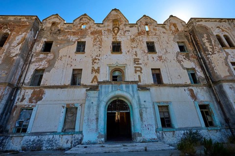 Lost Place, Verfallene Fassade eines Gebäudes mit verblassender Schrift und architektonischen