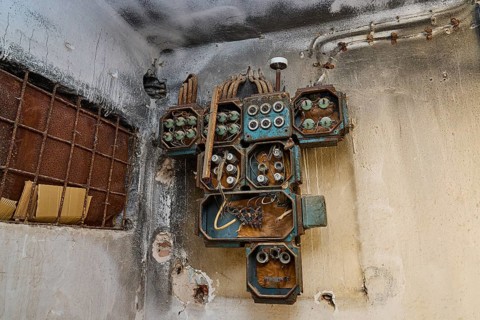 Lost Place, Rostige alte Elektrogeräte an einer verwitterten Wand im Gebäude, Caserma Avieri,