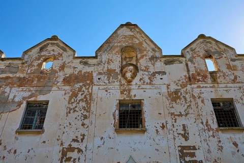 Lost Place, Verfallene Fassade eines alten Gebäudes vor klarem Himmel, Caserma Avieri, Gefängnis,