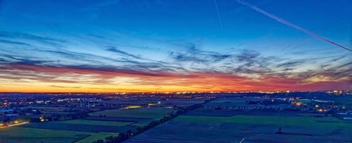 Panorama der Hamburger Vier- und Marschlande bei Nacht. Im Hintergrund die beleuchtete Silhouette
