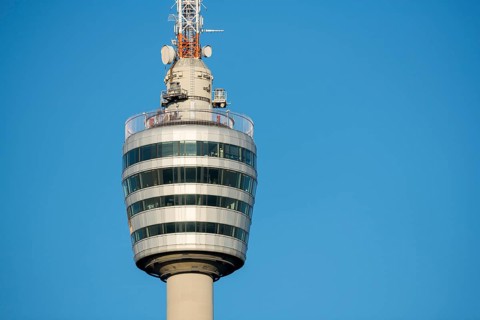 Detailaufnahme eines modernen Turms aus Glas und Metall vor blauem Himmel, Fernsehturm,