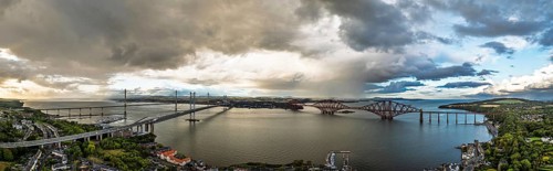 Sunset Panorama of Rain clouds over Forth Bridge from a drone, Queensferry Crossing, Forth Estuary,