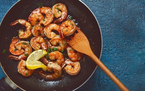 Fried tiger prawns, jumbo, in garlic sauce, in butter, with herbs, in a frying pan, homemade, no