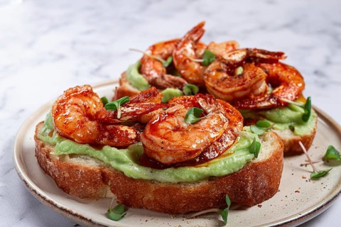 Sandwiches with avocado and caramelized shrimp, micro-greens, breakfast, on a plate, top view,