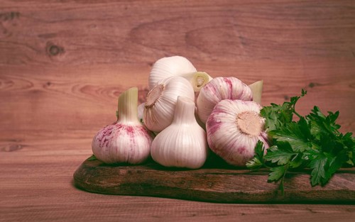 Fresh young garlic, white and purple color, on a wooden table, no people