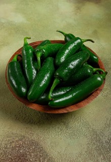 Fresh padron pepper, raw, in a wooden bowl, on the table, there are no people