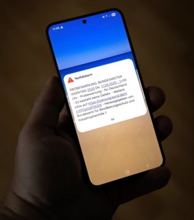 On 11 September 2025 at 11:00 a.m., a test warning appears on a smartphone, issued by the Federal