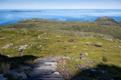 Woman with backpack climbing up stone stairs, Sherpat stairs or Midsund stairs or Midsundtrappene,